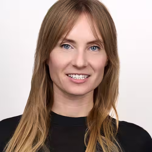 Fotograf headshot Leszno – biznesowy portret Aleksandry Łoś, uśmiechniętej kobiety o jasnych włosach i niebieskich oczach, w czarnej bluzce, na jasnym tle.